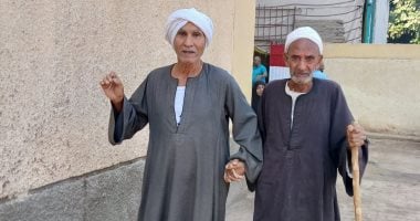 مسنان يتعاونان للتصويت في انتخابات النواب بمحافظة قنا