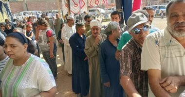 ناخبون يصطفون في طوابير أمام مدرسة بأسوان لتصويتهم.